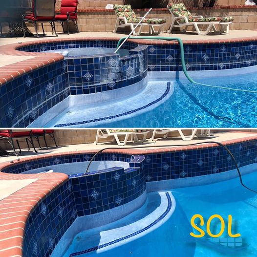 Blue tiled swimming pool with lounge chairs and cleaning hose