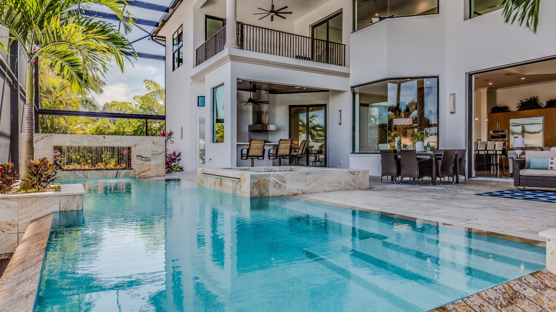 Modern two-story home with turquoise pool and tropical landscaping